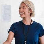 Friendly businesswoman in a blue shirt shaking hands during meeting, radiating professionalism and approachability.