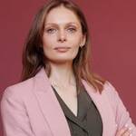 Elegant businesswoman with arms crossed in studio portrait, showcasing leadership and confidence.