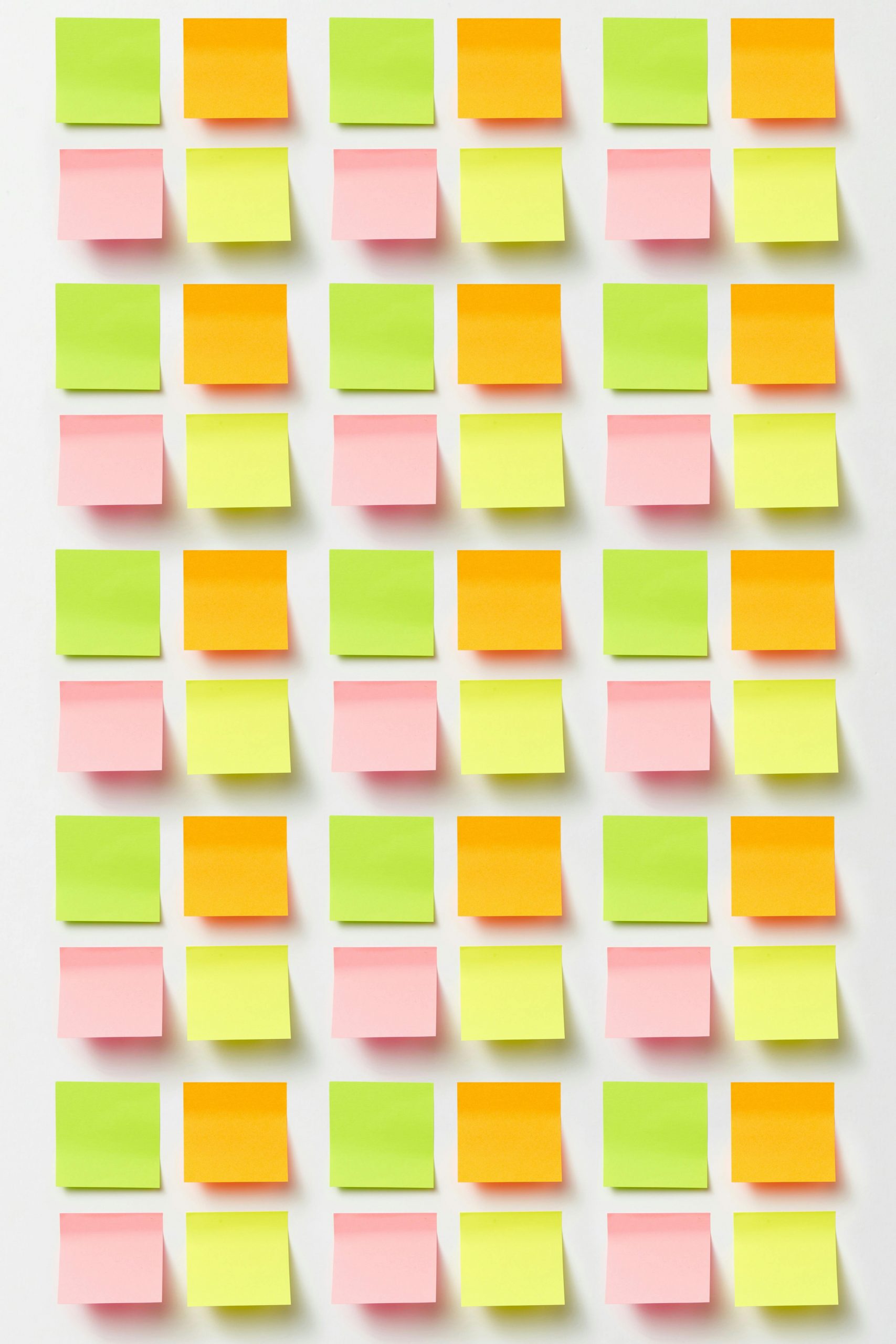Brightly colored sticky notes arranged in a grid pattern on a white surface.